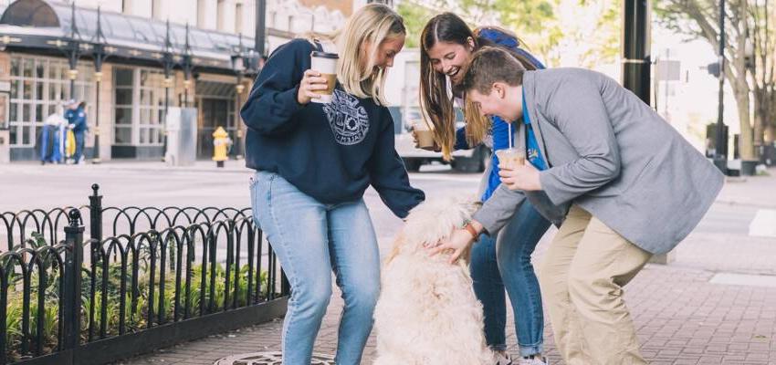 Salem College students petting a dog